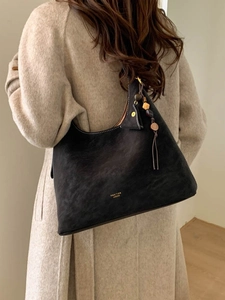 Retro black matte leather large tote bag with decorative wooden beads on model shoulder