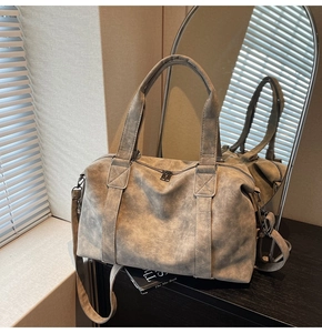 Detail of vintage grey tote bag showing wide handles, metal zipper and grainy texture