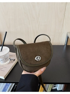 Detail of retro saddle bag showing brown matte finish and green leather trim with silver lock