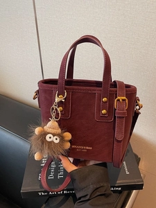 Fashionable burgundy tote bag with gold lettering and brown plush charm on books