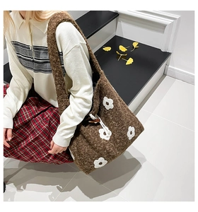 Close-up of brown plush tote bag featuring white 3D flower embroidery and drawstring