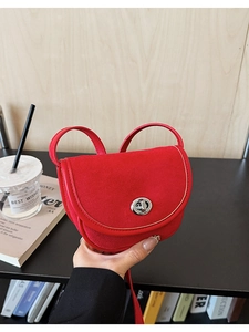 Detail view of red suede saddle bag with silver twist lock and premium leather strap