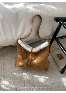 Detail of brown suede tote with white faux fur trim and vintage embossed patterns