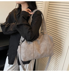 Detail of grey vintage tote bag with adjustable strap and textured leather finish