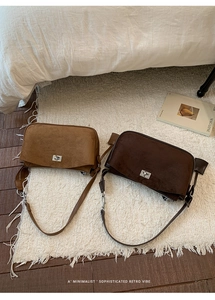 Flat lay of retro tan and dark brown suede shoulder bags with silver twist locks