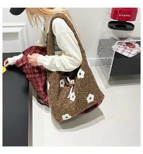 Detail of the brown knit shoulder bag showing floral embroidery and soft woven texture