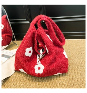 Detail of red plush floral shoulder bag with white flower and toggle closure