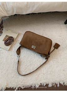 Detail of brown suede shoulder bag with silver turn-lock and adjustable strap