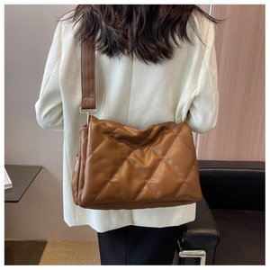 Detailansicht der braunen gesteppten Kunstledertasche mit breitem Schultergurt-Design