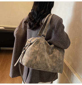 Detail of vintage gray faux leather tote bag showing large capacity and crossbody strap