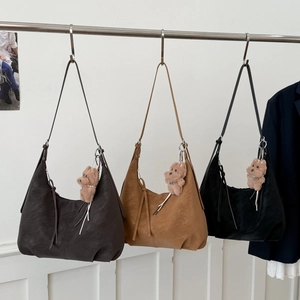 Three large PU leather dumpling bags in dark brown, caramel, and black with bear charms