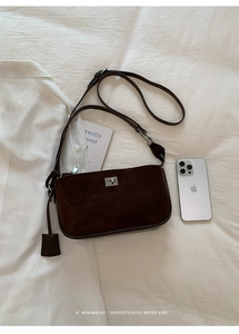 Close-up of a vintage brown suede shoulder bag with silver turn-lock and metallic zipper