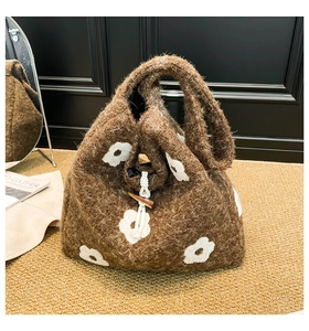 Detail of plush tote bag with flower embroidery and drawstring toggle closure