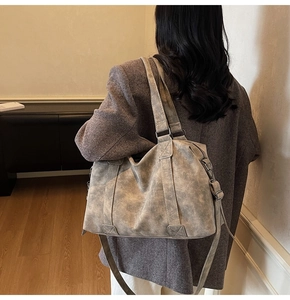 Detail of grey retro textured tote bag featuring wide handles and adjustable strap