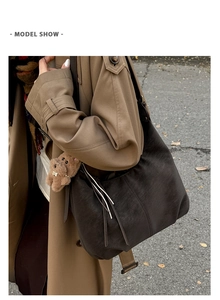 Detail of vintage large capacity brown shoulder bag with tassel zip and bear charm