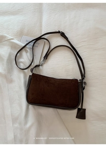 Flat lay of vintage dark brown suede shoulder bag with polished silver hardware