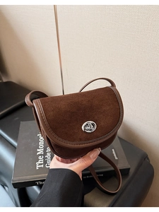 Close-up of retro mini saddle bag in dark brown suede with silver swivel lock clasp