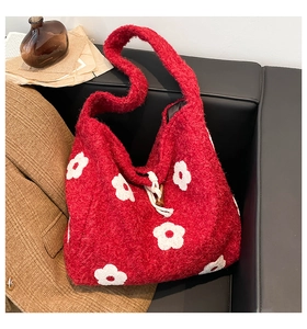 Detailed view of red plush tote bag featuring floral embroidery and wooden horn button