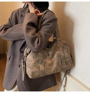 Close-up of vintage grey tote bag showing matte texture and dual handle detail on model