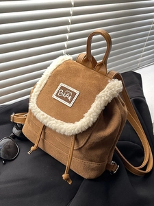 Brown suede mini backpack with white sherpa trim and bear patch on the front flap