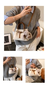 Detail of a beige bucket bag with brown handles and a cute plush dog charm accessory