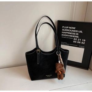 Détail du sac cabas noir mat avec surpiqûres blanches et un charmant ours en peluche