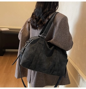 Model wearing dark grey oversized tote bag made of high-quality frosted texture leather