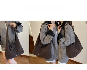 Détail d'un grand sac cabas marron en daim avec breloque cœur et imprimé logo blanc