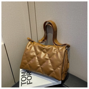 Detail of brown quilted diamond pattern on large leather shoulder bag with soft texture