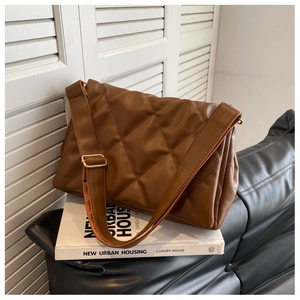 Detailansicht der braunen Stepptasche mit Rautenmuster und breitem Schultergurt