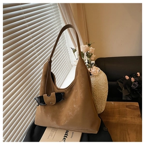 Sac cabas en daim marron avec porte-lunettes dans un cadre lumineux doux et chaleureux