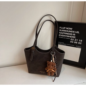 Détail du sac cabas en cuir anthracite avec surpiqûres blanches et charme d'ours