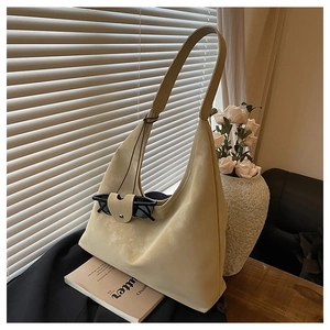 Détail du grand sac hobo beige avec bandoulière large tenant des lunettes de soleil ici