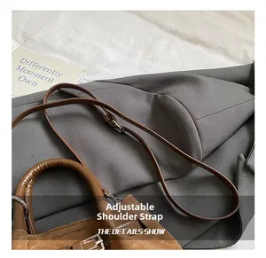 Detail of adjustable shoulder strap and stitching on brown vintage pleated handbag