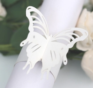 Detail of laser-cut butterfly napkin ring made of white paper for wedding decoration