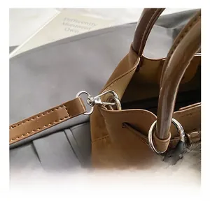 Detailed close-up of high-quality silver metal hooks and premium leather bag strap