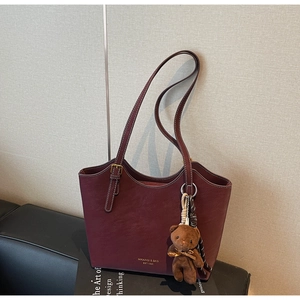 Détail du sac cabas bordeaux avec surpiqûres contrastées et breloque ours mignonne