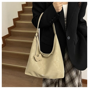 Vue détaillée du grand sac hobo beige avec bandoulière large et pochette ronde assortie