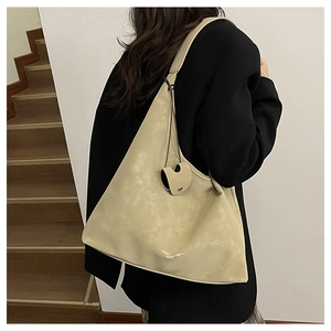 Vue détaillée du sac cabas en cuir crème avec finition texturée et large bandoulière souple