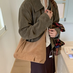 Close-up of caramel brown suede hobo bag with vintage texture and sleek shoulder strap