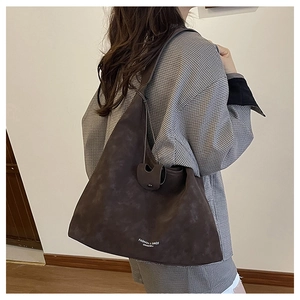 Détail du grand sac cabas marron foncé avec lettrage blanc et bandoulière à nœuds