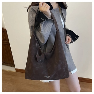 Détail du grand sac cabas en daim marron foncé avec une petite pochette assortie