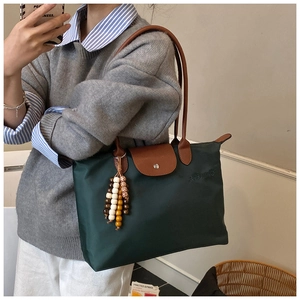 Détails de ce sac fourre-tout en nylon vert foncé avec poignées en cuir et logo
