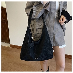 Détail du grand sac cabas en similicuir noir avec pendentif en forme de cœur