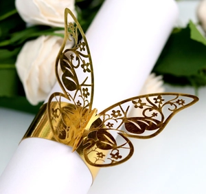 Close-up of golden laser-cut butterfly napkin ring with intricate hollow floral patterns
