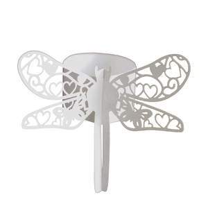 Macro view of white dragonfly paper napkin ring with laser-cut heart pattern details