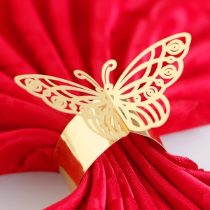 Elegant gold butterfly napkin ring with laser cut details on a red wedding napkin