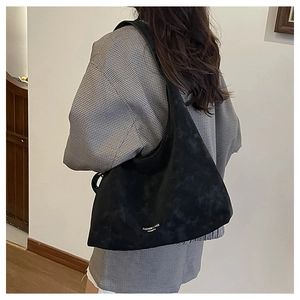 Détail d'un grand sac hobo noir montrant la texture et l'imprimé 'FASHION & BAGS'
