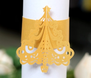 Macro view of golden laser-cut Christmas tree napkin rings for festive table decor