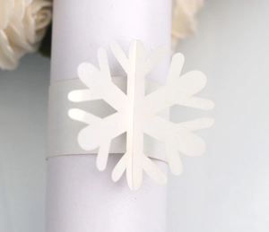 Close-up of laser-cut white snowflake paper napkin ring for wedding and holiday decor